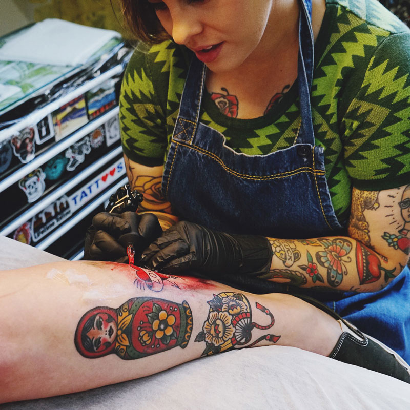 Tattoo artist tattooing an arm tattoo